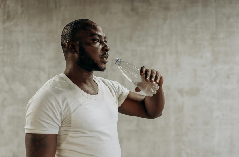 Person trinkt Wasser und treibt Sport fuer schnelleren THC-Abbau